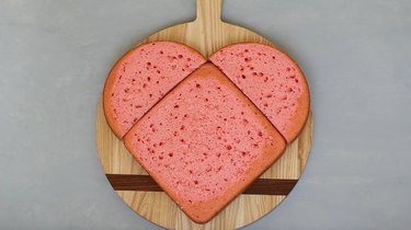 Round cake halves placed above square cake in heart shape
